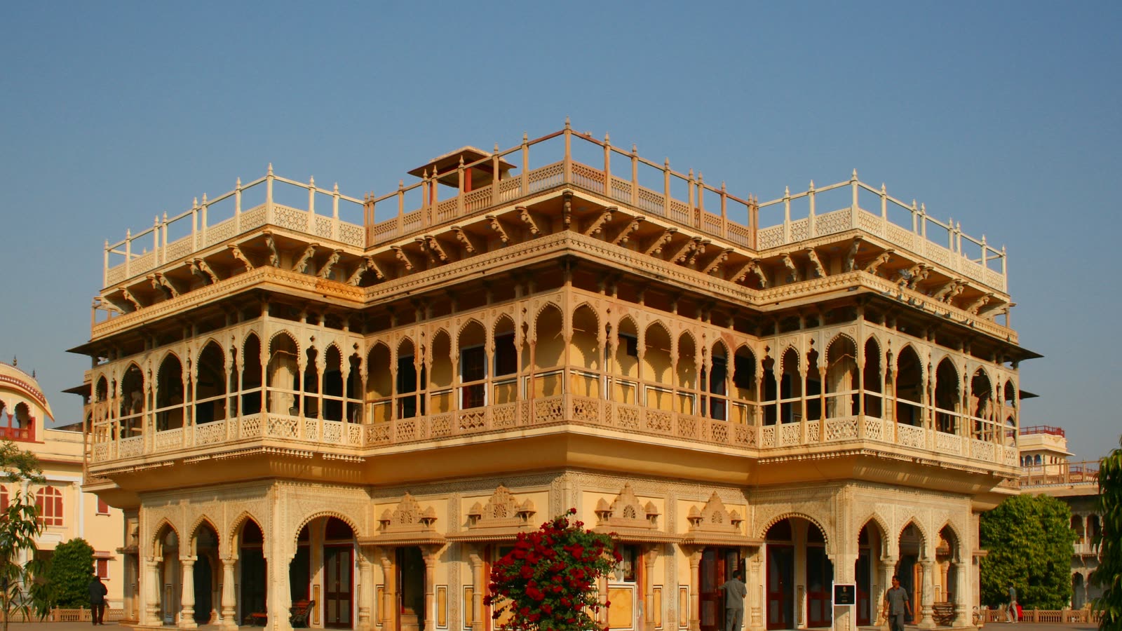 Mubarak Mahal in the City Palace, a cream two-storey building with carved balconies and arches, in warm evening light
