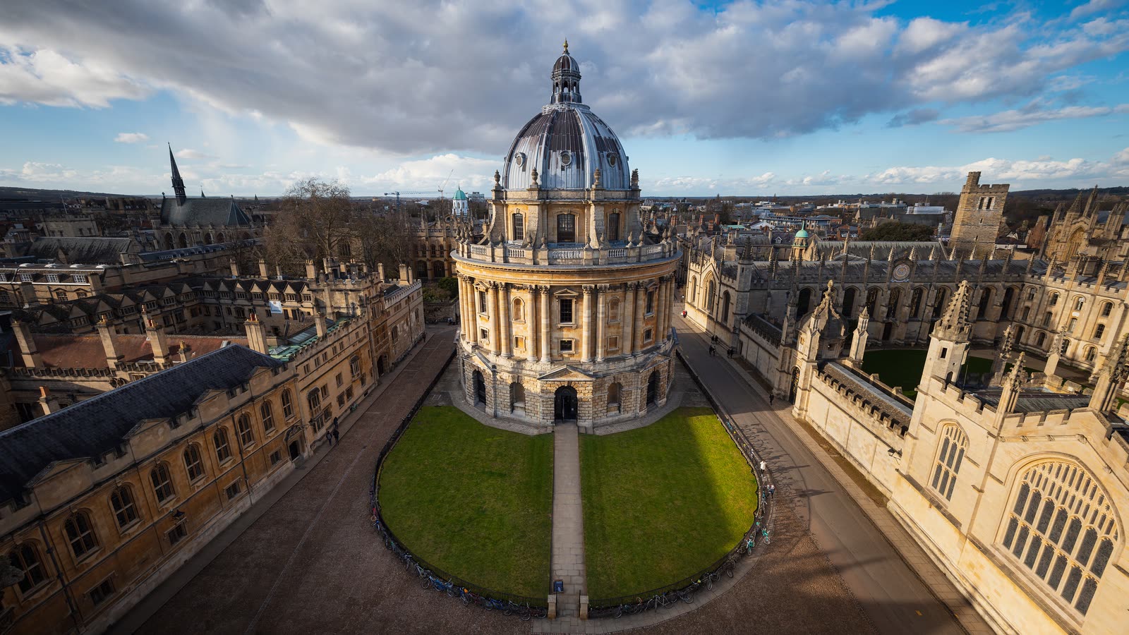 The domed Radcliffe Camera in a square of lawn, surrounded by Oxford's old college buildings