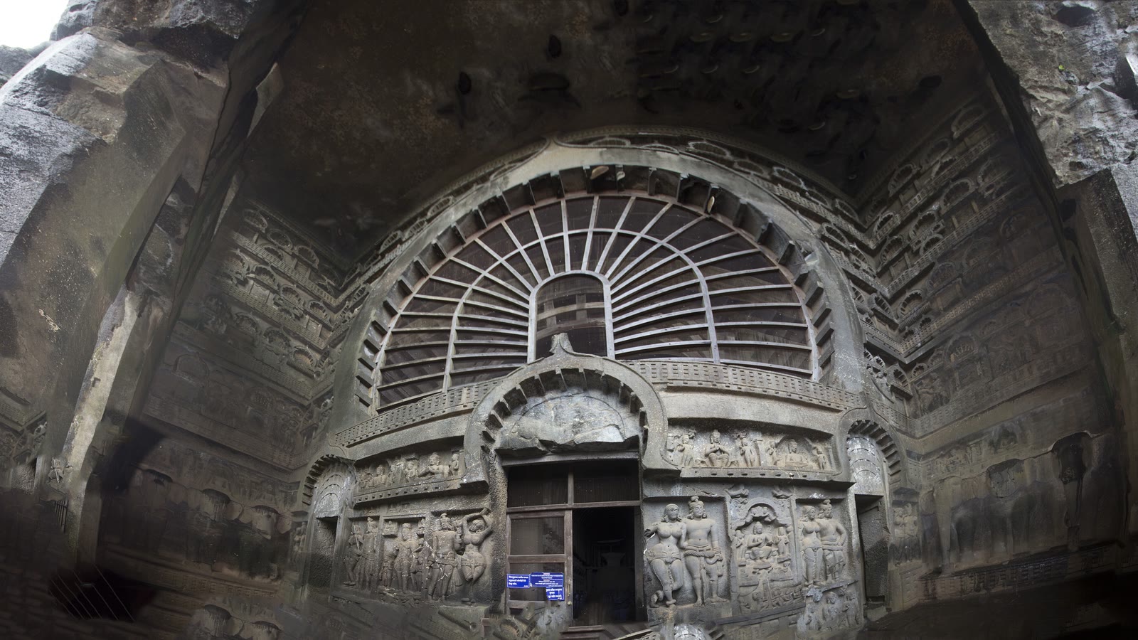 The carved stone facade and large horseshoe-shaped window of the main cave hall at Karla