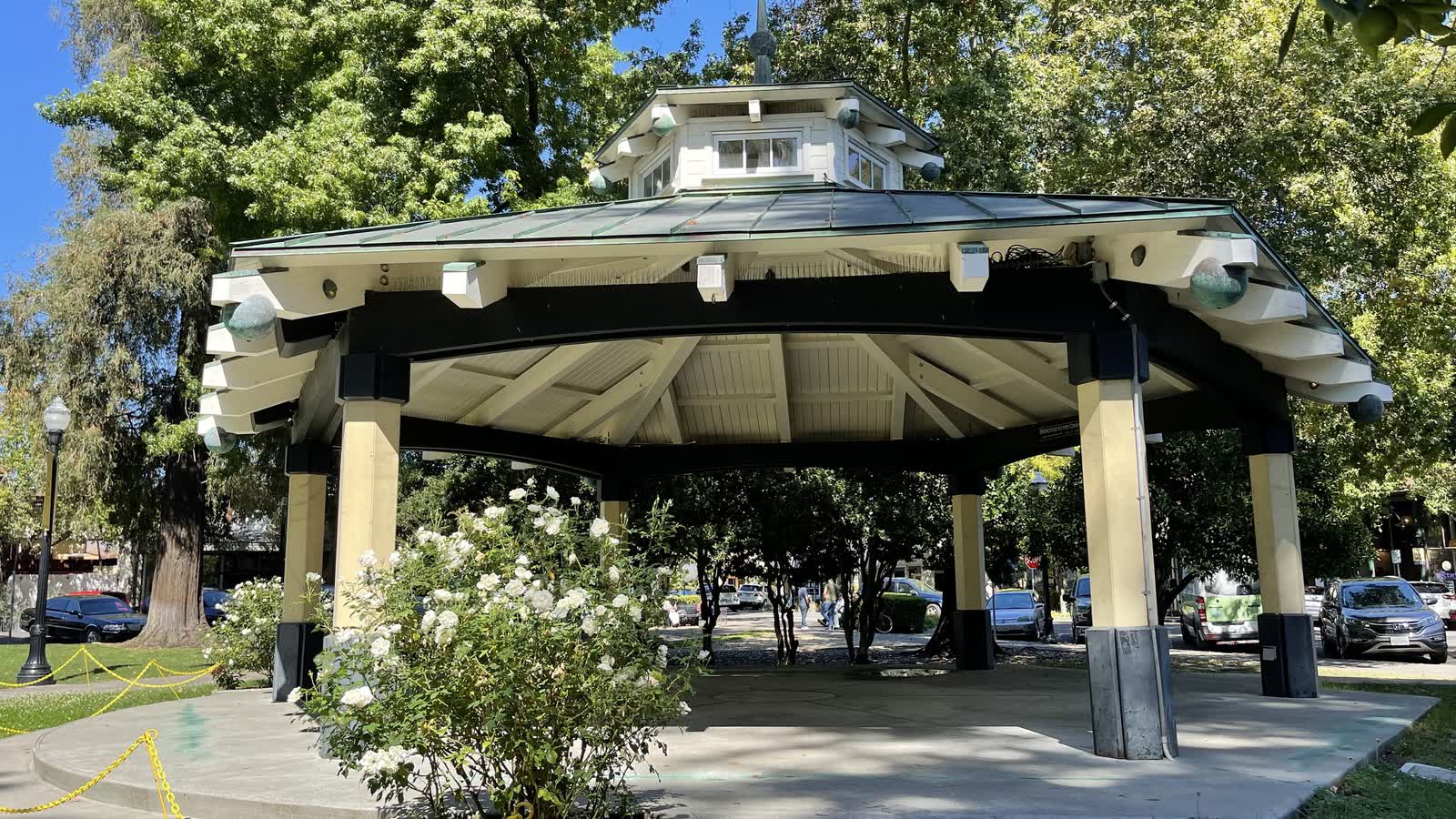 A white wooden gazebo among trees and white roses on the town plaza in Healdsburg